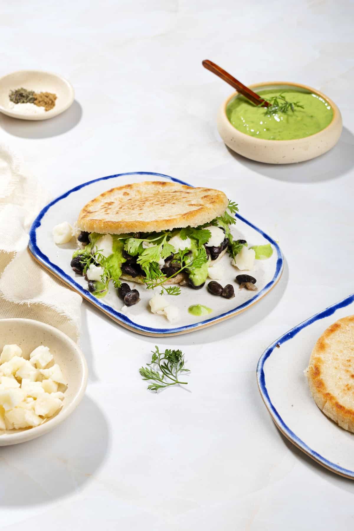 Pan-Fried Cornmeal Arepas with Black Beans and Cilantro Garlic Sauce