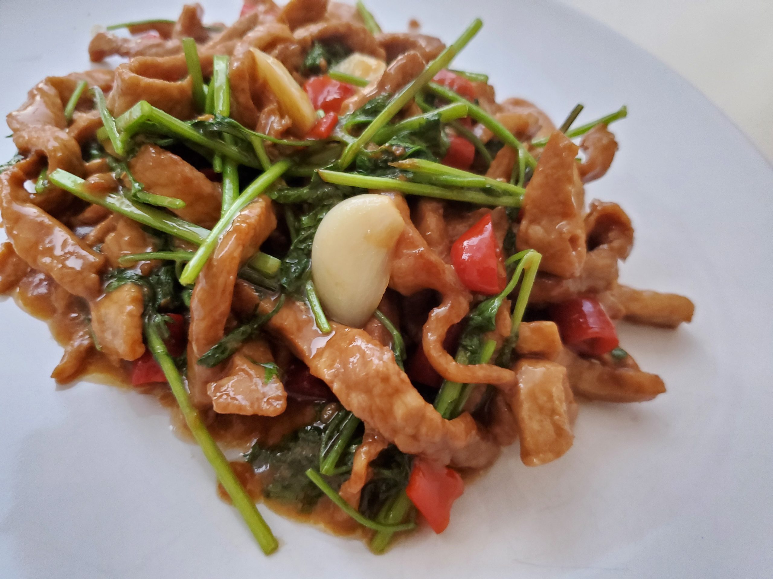 Spicy Stir-Fried Pork with Pickled Chilies and Garlic Scapes