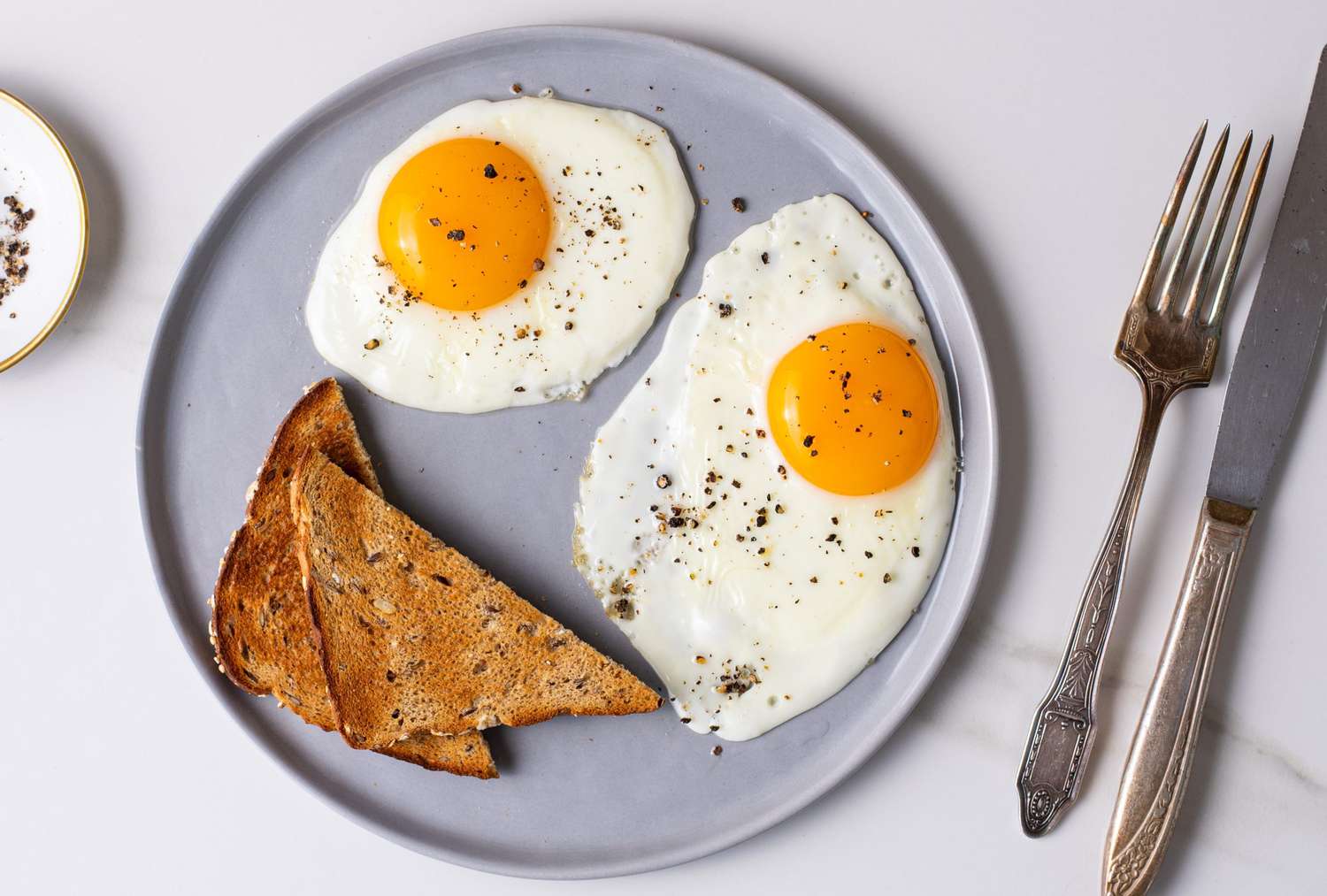 Sunny-Side Up Eggs with Melted Cheddar on Whole Wheat Toast
