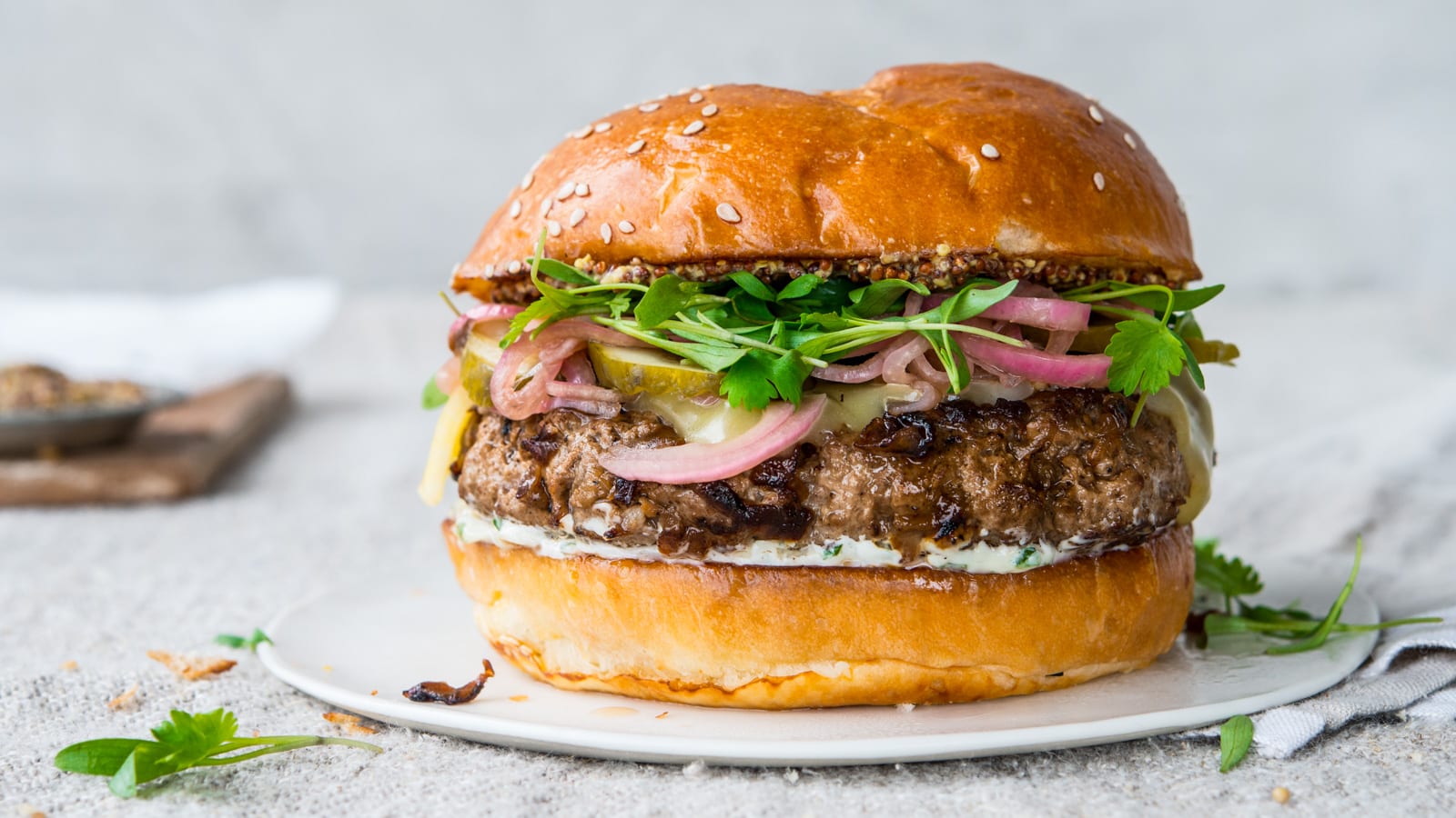 Grilled Grass-Fed Beef Burger with Caramelized Onions and Aged Cheddar